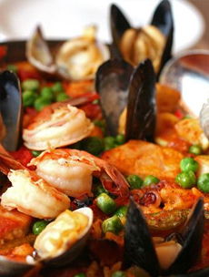 西班牙海鲜饭源自西班牙的瓦伦西亚，是一道以海鲜为主料，配以多种香料和米饭制成的美食